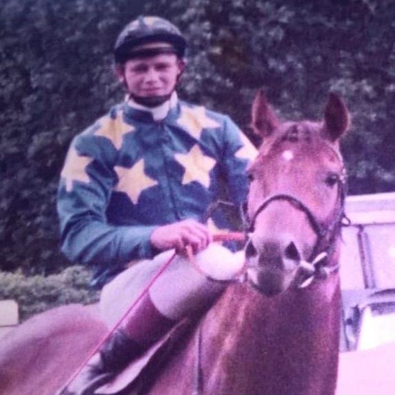 Jockey in star-patterned silks riding a chestnut horse
